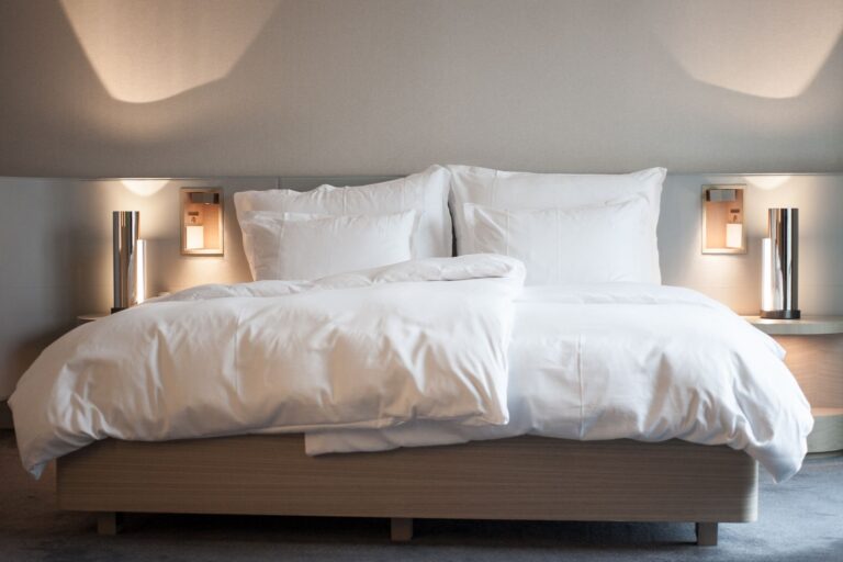 Hotelværelse med høj seng og sengetøj