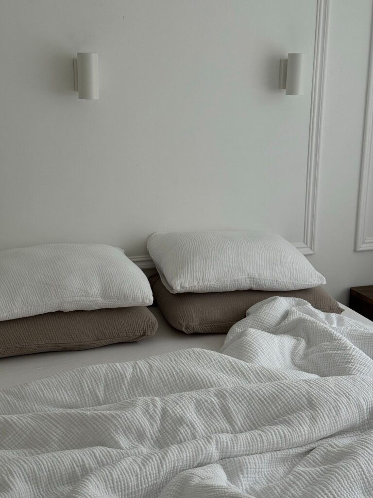 Minimalistisk soveværelse med bløde puder og hvidt sengetæppe