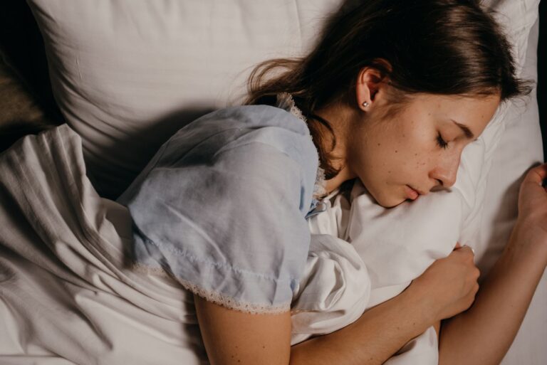 Kvinde sover på en hvid pude om natten
